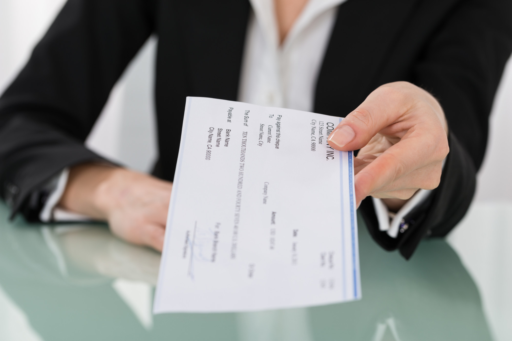 Manager giving a payroll check to an employee